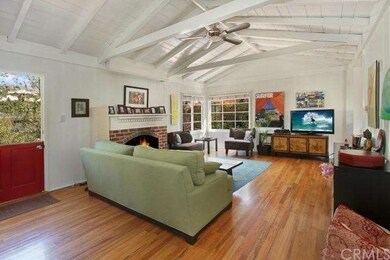Cottage living area with fireplace, open beam ceil