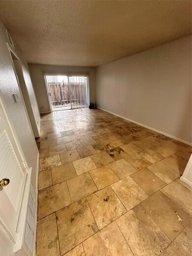 Empty room featuring stone tile floors and a text