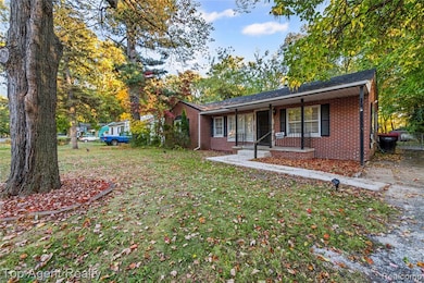 Ranch-style house featuring a front yard, brick siding, and covered porch