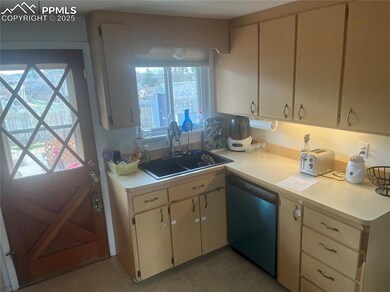Kitchen with light countertops, a sink, dishwashin