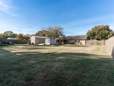 Fenced backyard featuring a storage shed