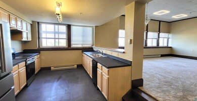 Kitchen with a baseboard heating unit, stainless steel appliances, and dark countertops
