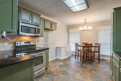 Kitchen with backsplash, green cabinets, stainless