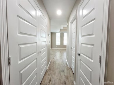 Hall with light wood-style floors and baseboards