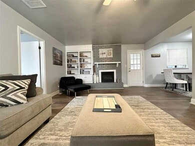 Living room featuring a fireplace, dark wood-type 
