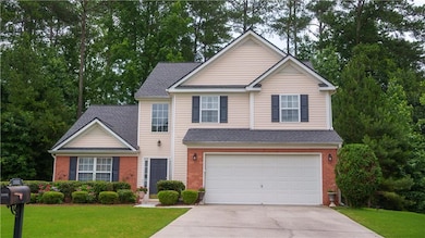 Traditional home with driveway, a garage, a front yard, and brick siding