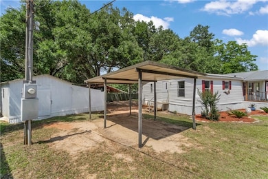 View of patio with a carport and dirt driveway