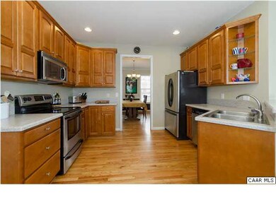 Kitchen features stainless appliances,  wood floor
