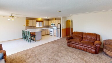 Living room with sink, ceiling fan, light tile flo