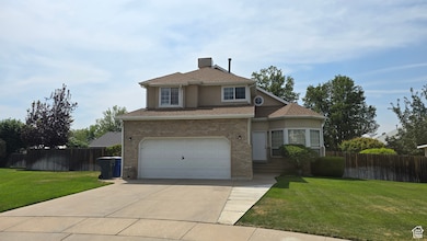 Traditional-style home with driveway, a garage, brick siding, a shingled roof, and stucco siding