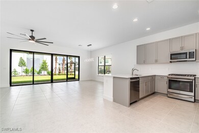 Kitchen with gray cabinets, appliances with stainless steel finishes, open floor plan, a peninsula, and recessed​​‌​​​​‌​​‌‌​​​‌​​‌‌​‌‌​​​‌‌‌​​​​‌​​​​​‌ lighting