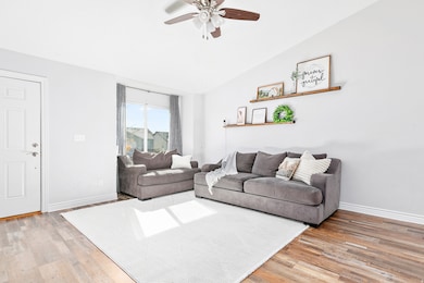 Bright and inviting living room abundant natural light and  LVP flooring ceiling fan.