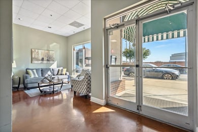 Doorway featuring finished concrete flooring, baseboards, and a paneled ceiling