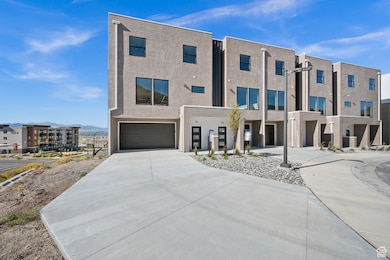 Contemporary home with concrete driveway, a garage, a mountain view, and stucco siding