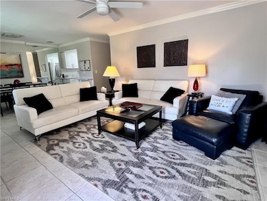 Living area featuring ornamental molding, ceiling fan, and light tile patterned floors