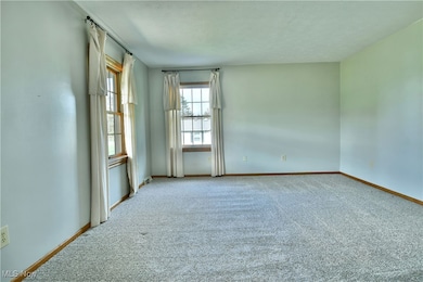 Unfurnished room featuring carpet and baseboards