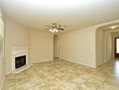 Unfurnished living room with arched walkways, a premium fireplace, and a ceiling fan