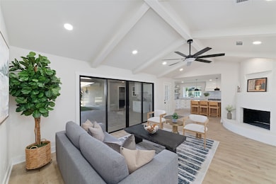Family Room looking into the kitchen and outdoor patio. The plastered fireplace anchors the room.