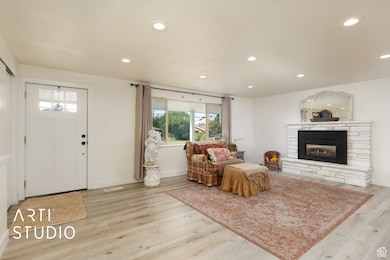 Entrance foyer featuring recessed lighting, wood finished floors, and a stone fireplace