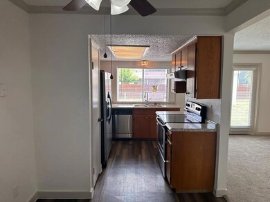 Kitchen with a textured ceiling, ceiling fan, appl