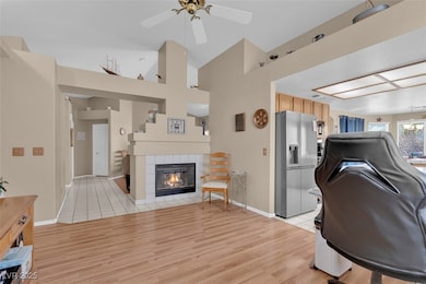 Living area featuring a ceiling fan, light wood-ty