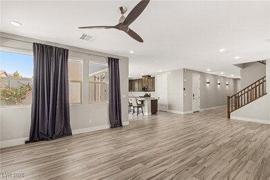 Living room with a ceiling fan, light wood-style f
