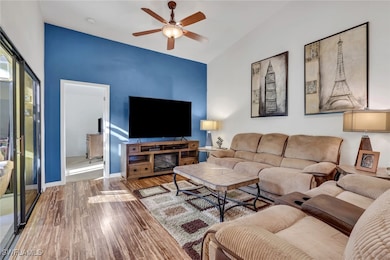 Living room featuring wood finished floors, ceiling fan, and lofted ceiling