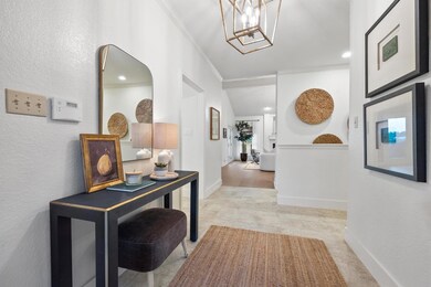 Corridor with ornamental molding and a chandelier