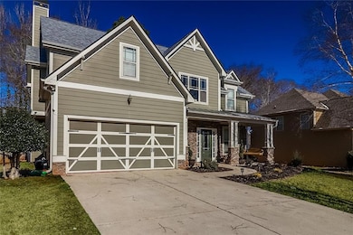 Craftsman house with a porch, an attached garage, concrete driveway, a chimney, and a front yard