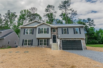 Split foyer home featuring stone siding, driveway,