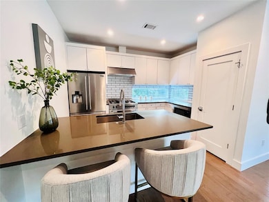 Kitchen with stainless steel refrigerator with ic