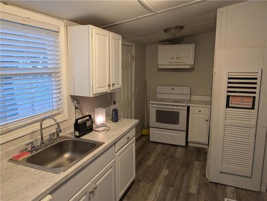 Kitchen with white electric range oven, white cabi