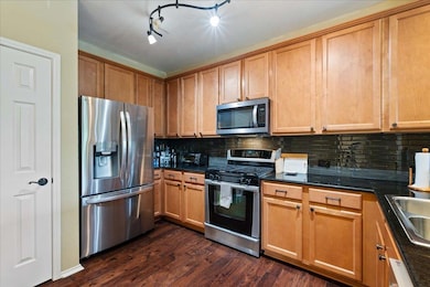 Kitchen featuring dark stone countertops, backspl