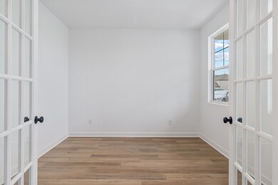 Spacious flex/office space accented by glass framed French doors.