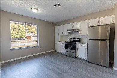 Kitchen with white cabinets, appliances with stain