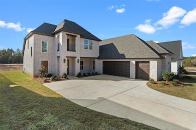 French country style house with a front lawn, brick siding, driveway, and a garage
