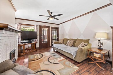 crown molding, fireplace, and ceiling fan