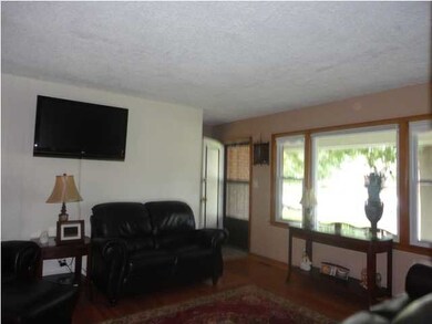 Living room features large window, hardwood floors