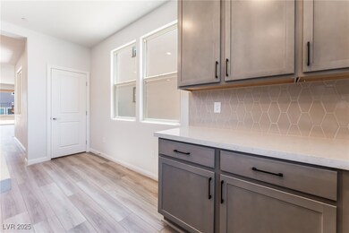 Kitchen featuring gray cabinetry, decorative backs