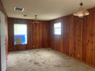 Carpeted empty room featuring cedar walls and visible vents