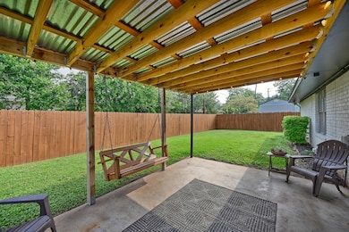 This backyard features a spacious covered patio wi