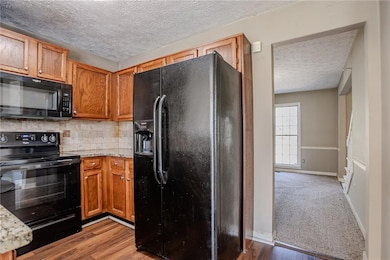 Kitchen with backsplash, baseboards, black applian