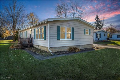 Property exterior at dusk featuring a yard and a wooden deck