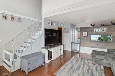 Living room featuring stairway, dark wood-style fl