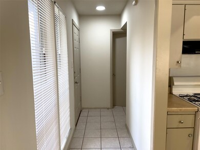 Hall with light tile patterned floors and baseboa