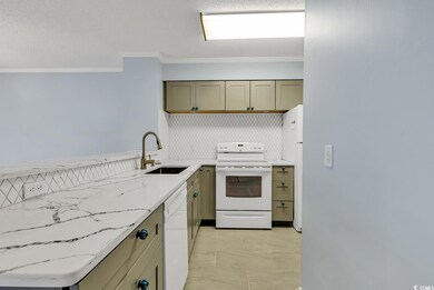 Kitchen with white appliances, light marble finish floors, crown molding, light stone countertops, and decorative backsplash