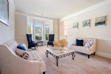The front Living Room is perfect for a Quiet Sitting Area or Home Office, flowing seamlessly into the elegant Formal Dining Room with Coffered Ceilings and Wainscoting Details.