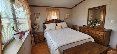 Bedroom with light wood-type flooring, multiple windows, and crown molding