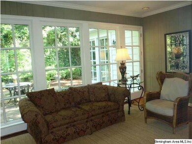 Den with wall of windows and two french doors lead