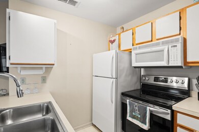 Kitchen featuring visible vents, a sink, white app